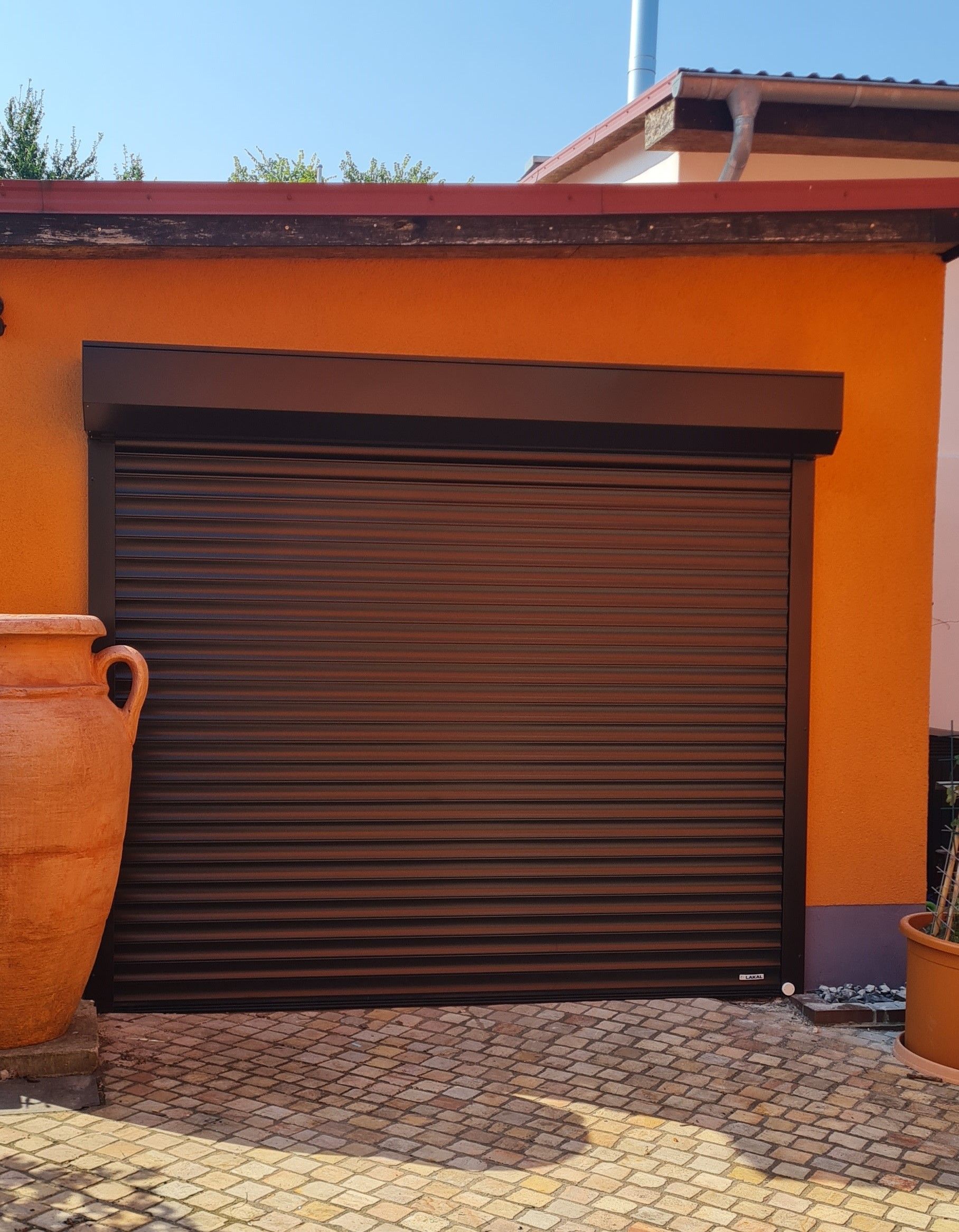 Eine orangefarbene Garage mit einem braunen Garagentor