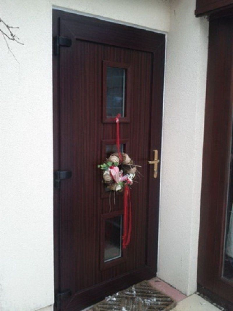 Eine braune Tür mit einem daran hängenden Kranz