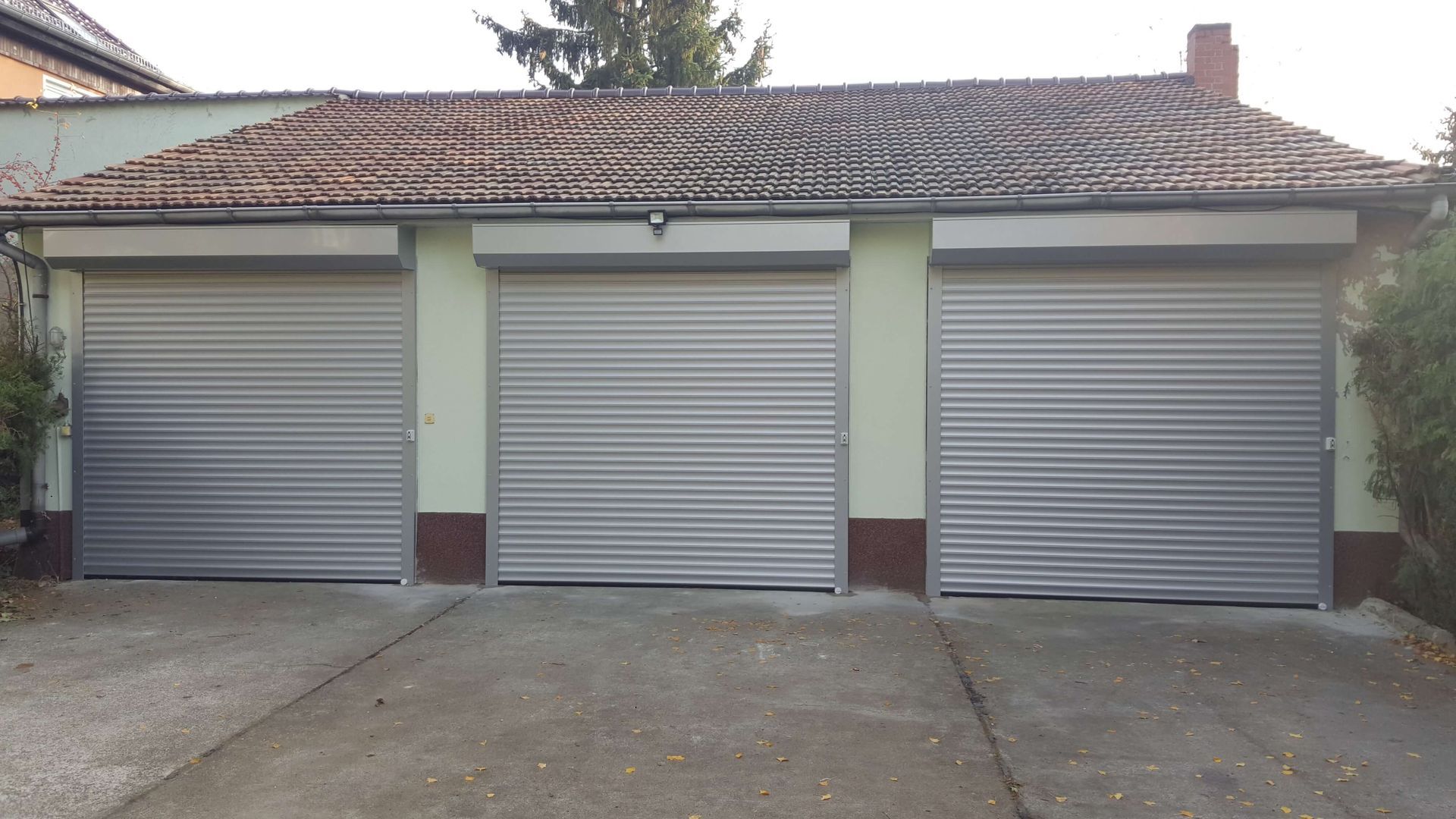 Eine Reihe von Garagentoren steht vor einem Haus