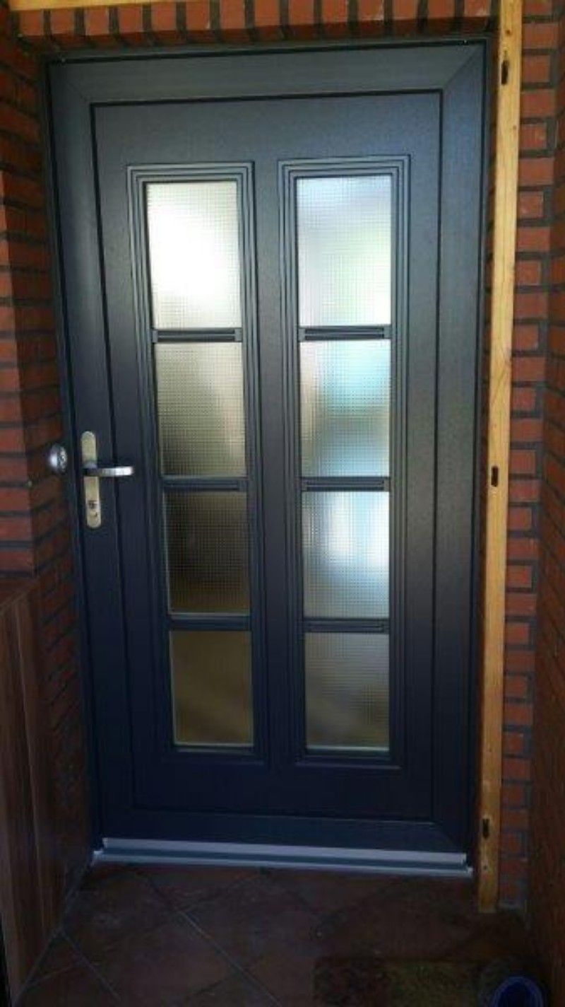 Eine schwarze Tür mit einer Ziegelwand dahinter