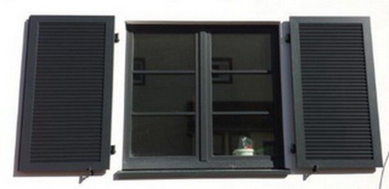 Ein Fenster mit zwei schwarzen Fensterläden