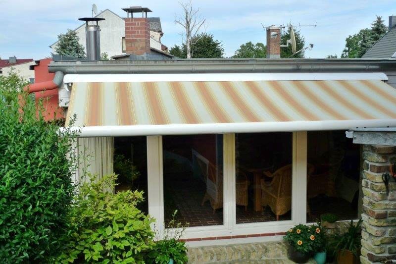 Ein Haus mit einer gestreiften Markise auf dem Dach