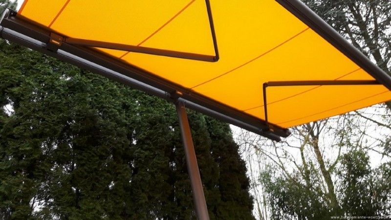 Eine gelbe Markise hängt an einer Metallstange