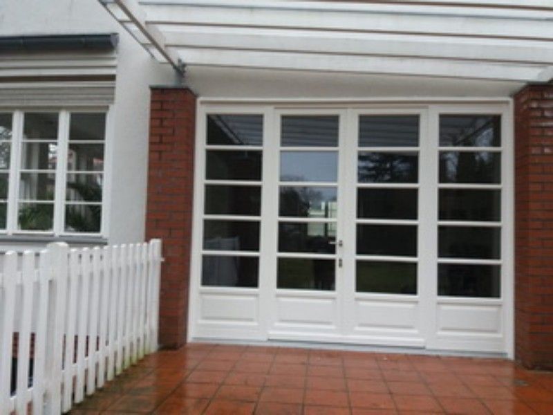 Ein weißer Zaun umgibt eine große weiße Tür