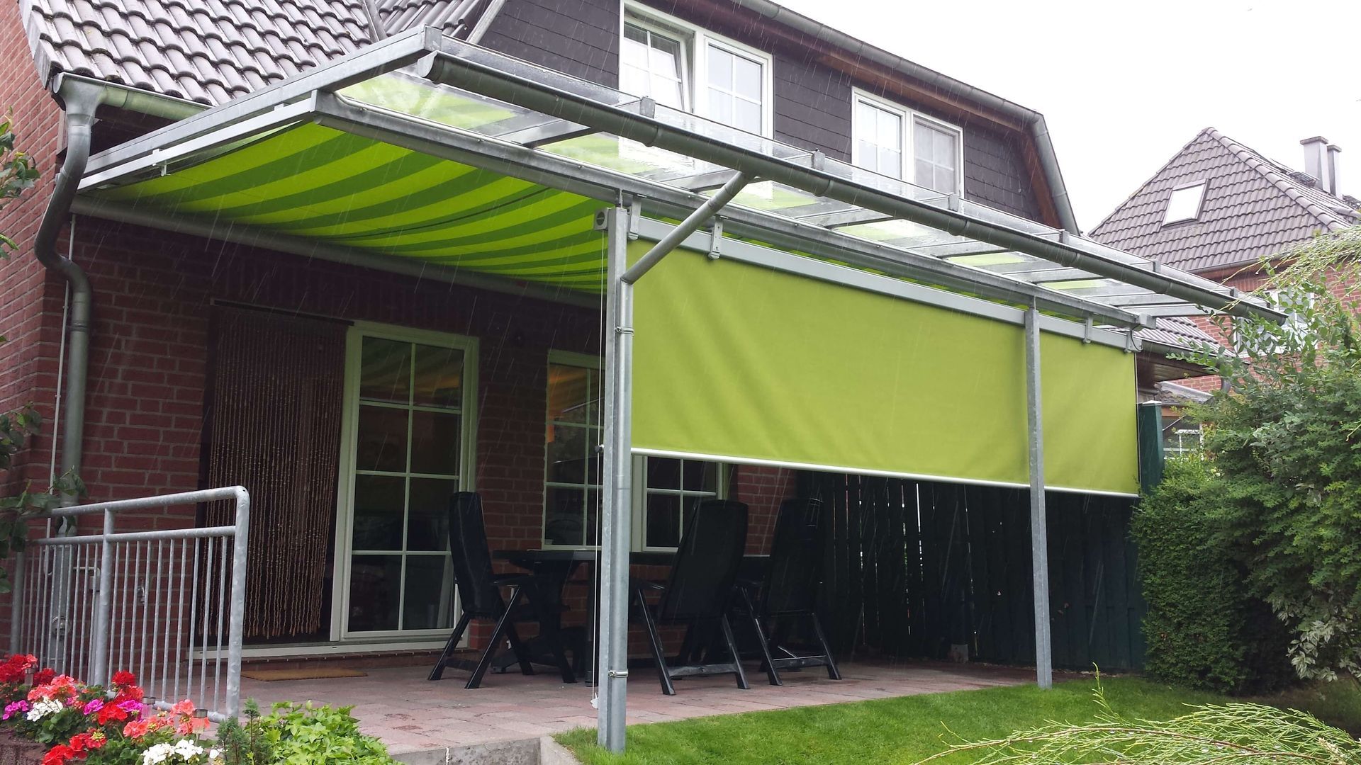 Ein Haus mit einer grünen Markise über einer Terrasse