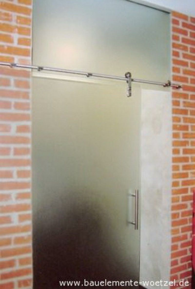 Eine Glasschiebetür mit einer Ziegelwand dahinter