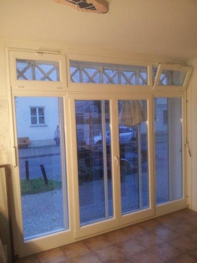 Ein Raum mit vielen Fenstern und einem Deckenventilator.
