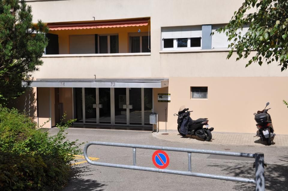 Deux scooters sont garés devant un bâtiment avec un panneau d'interdiction de stationnement