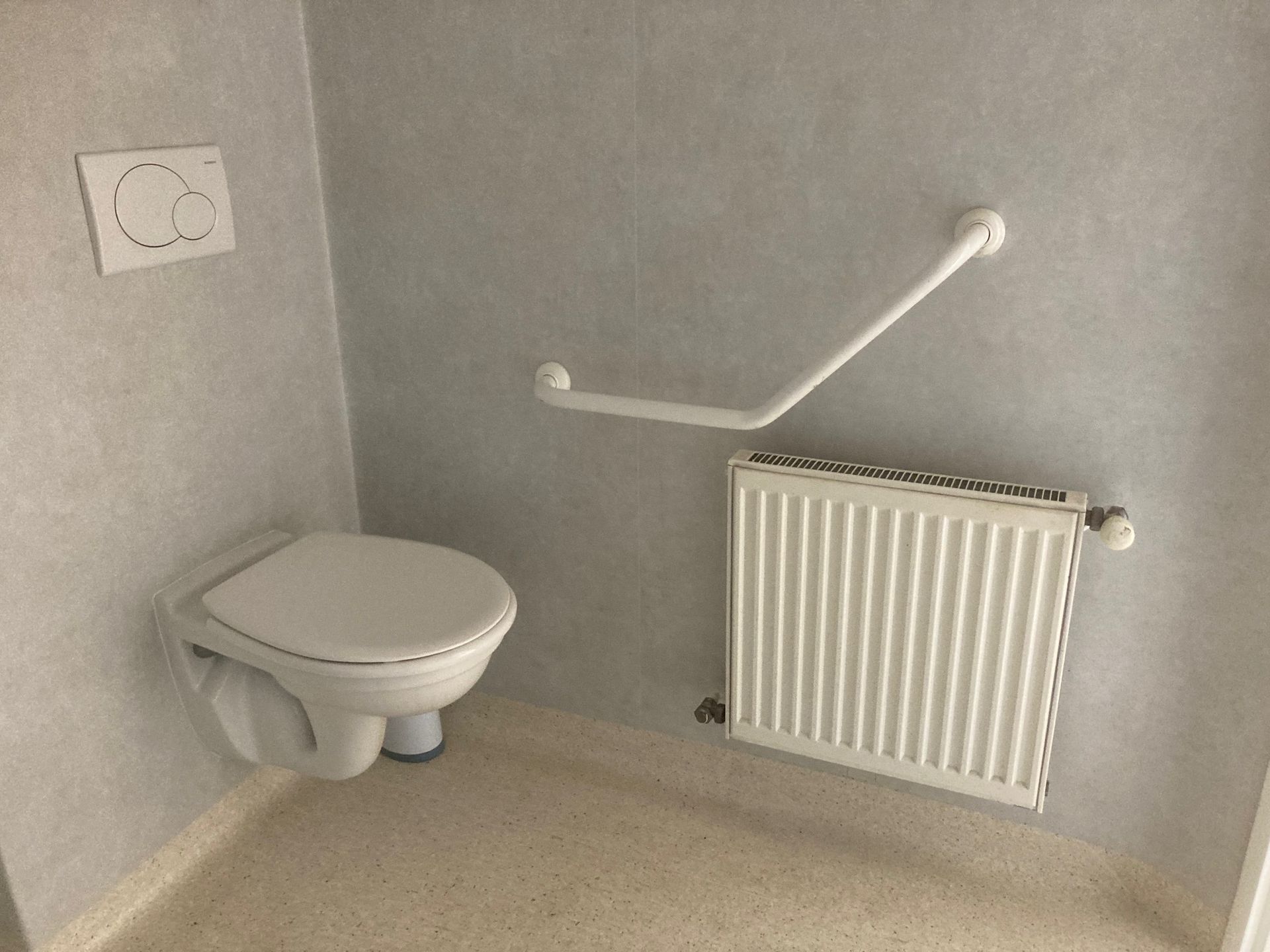 Toilettes d'une salle de bains avec  une barre d'appui