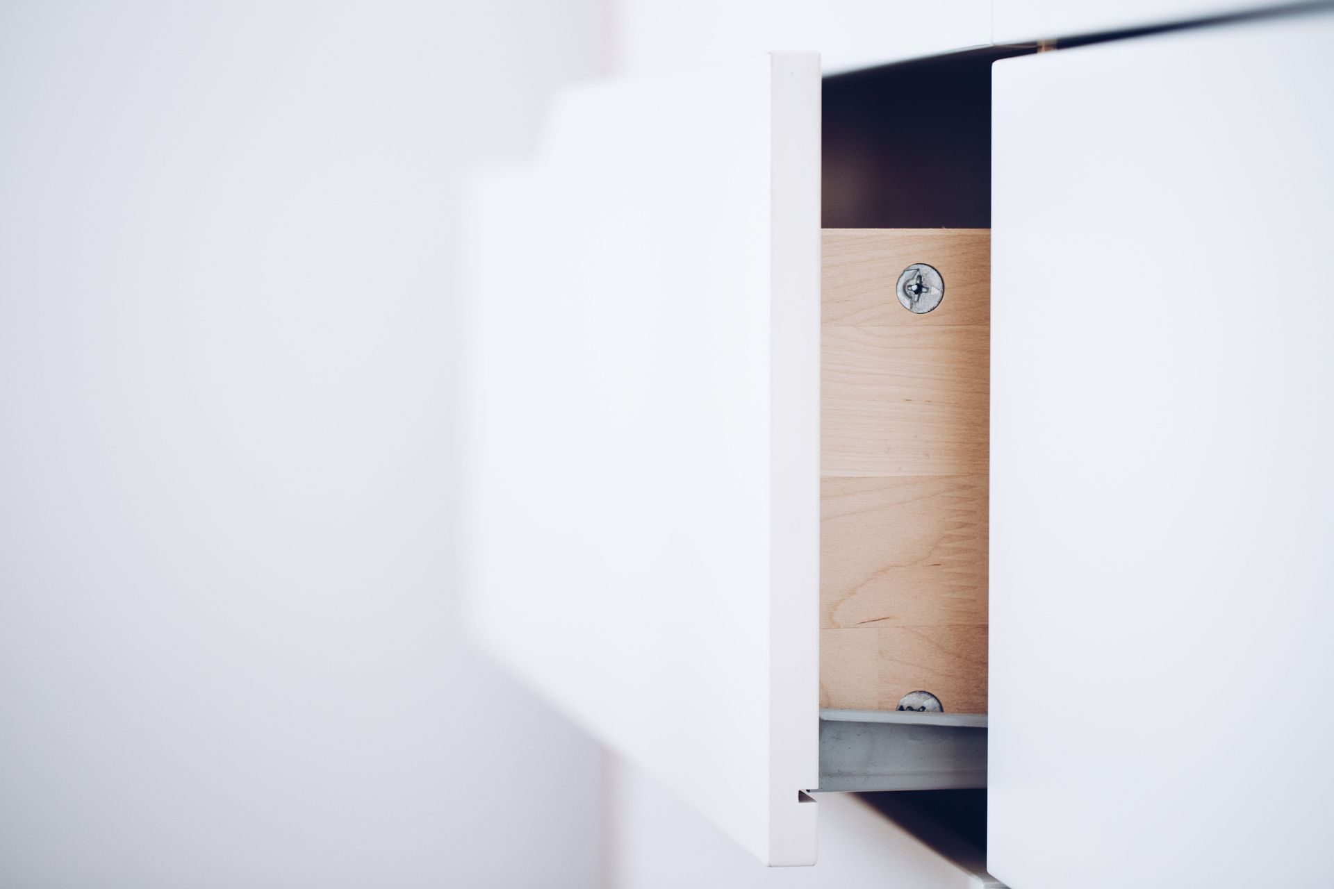 Ouvrez le placard blanc pour révéler un panneau en bois avec des vis à l’intérieur