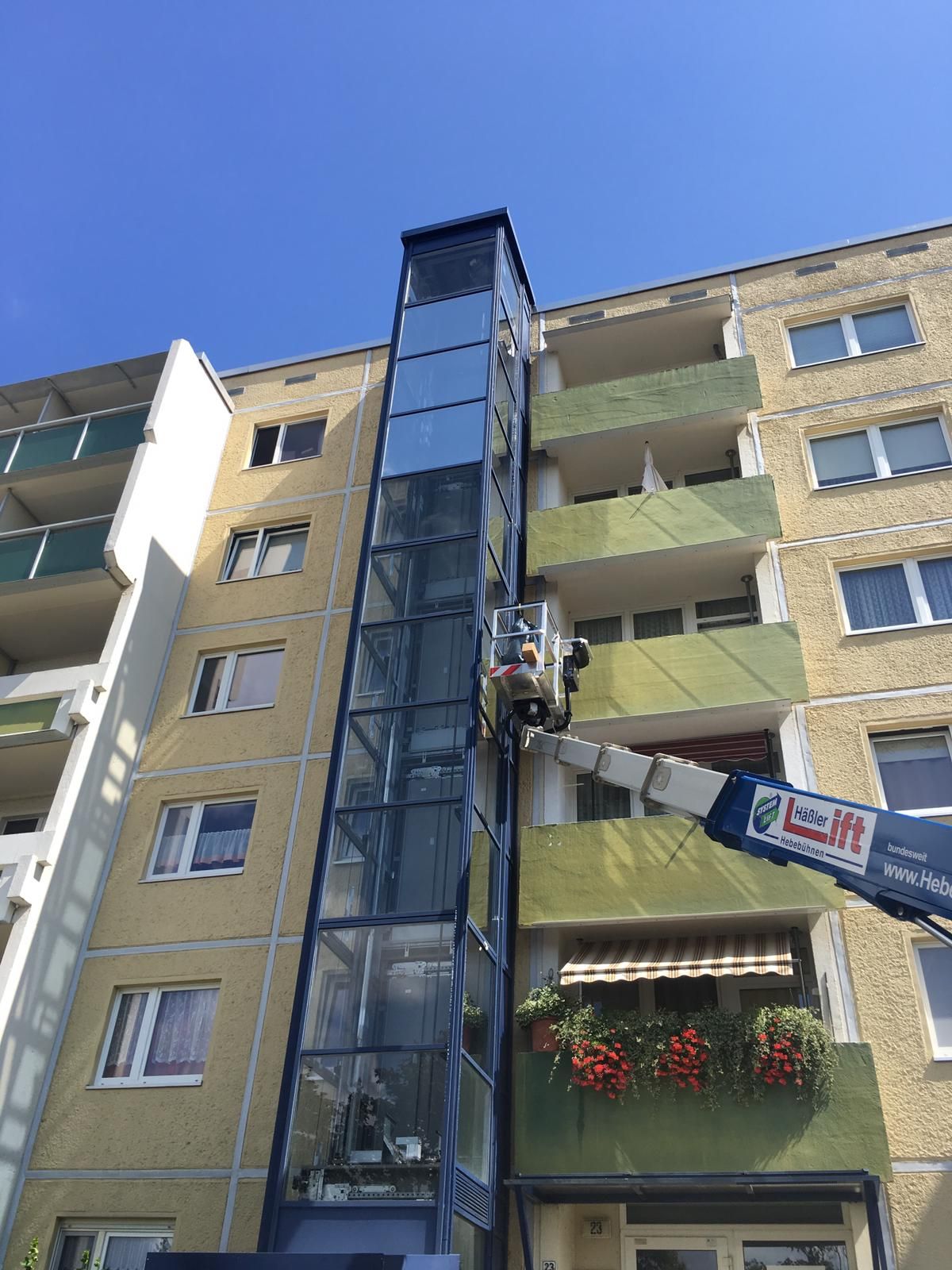 An der Seite eines Gebäudes wird ein Aufzug installiert.