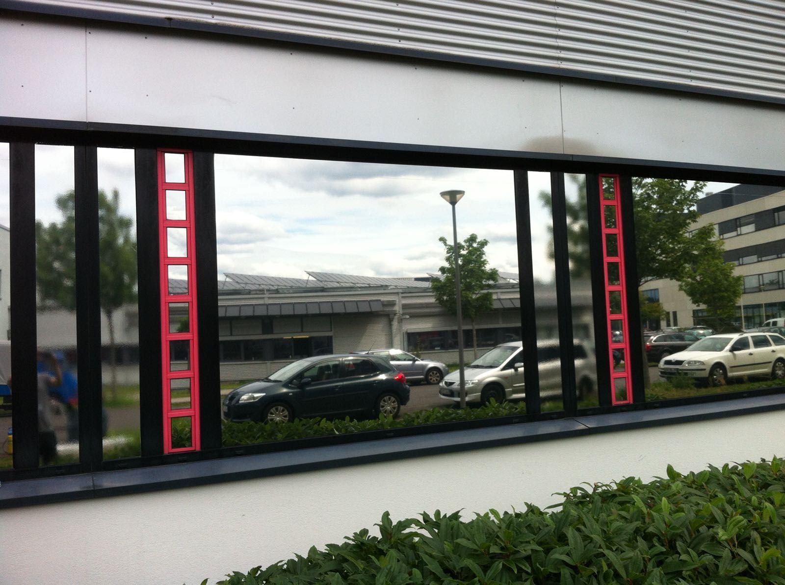 Eine Spiegelung von Autos in einem Fenster eines Gebäudes