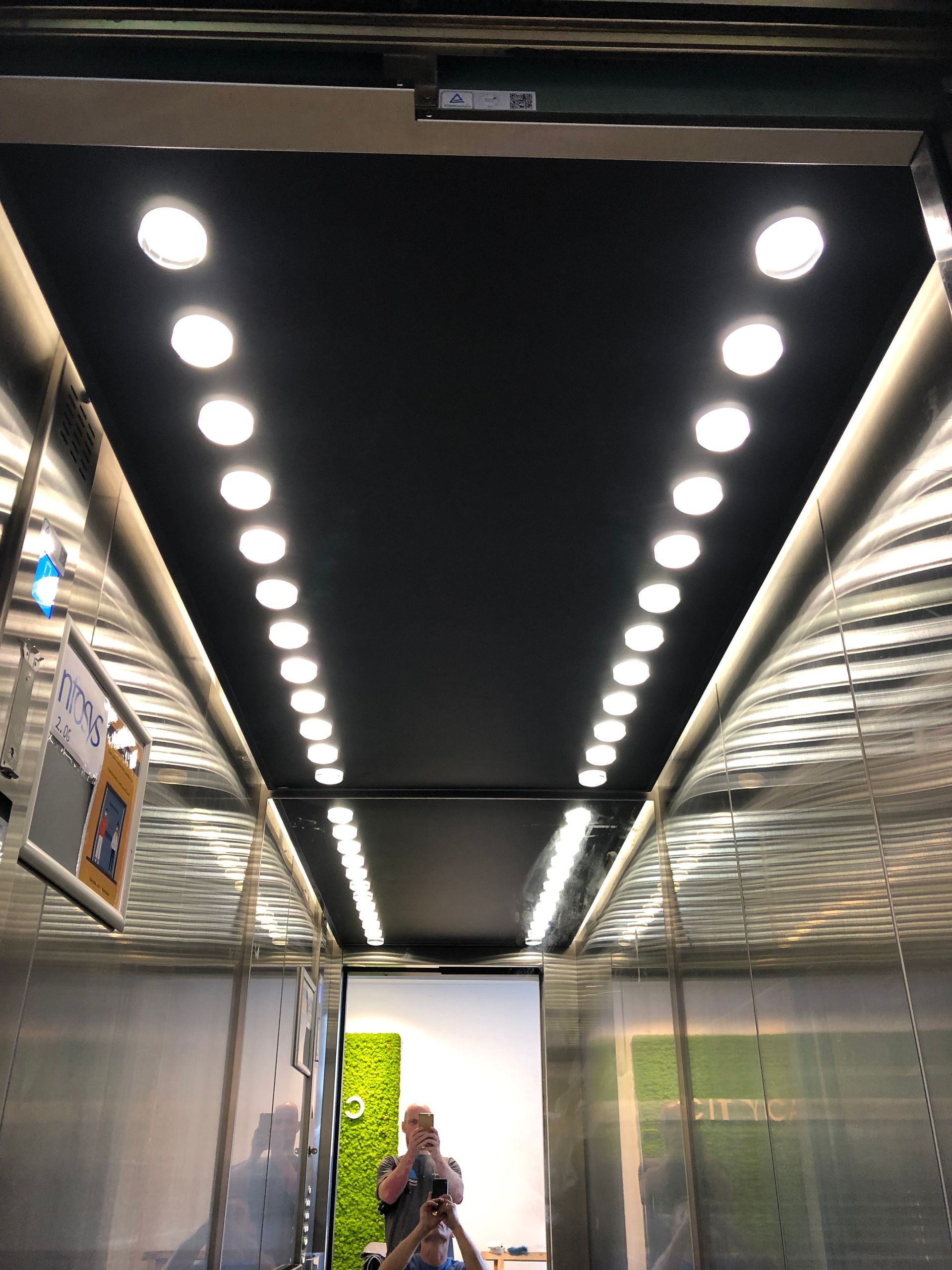 Ein Mann macht ein Foto von sich in einem Aufzug.