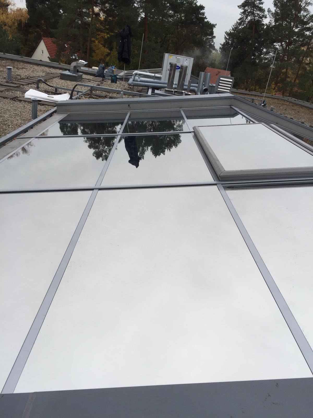 Ein Dach mit einer Spiegelung von Bäumen darin