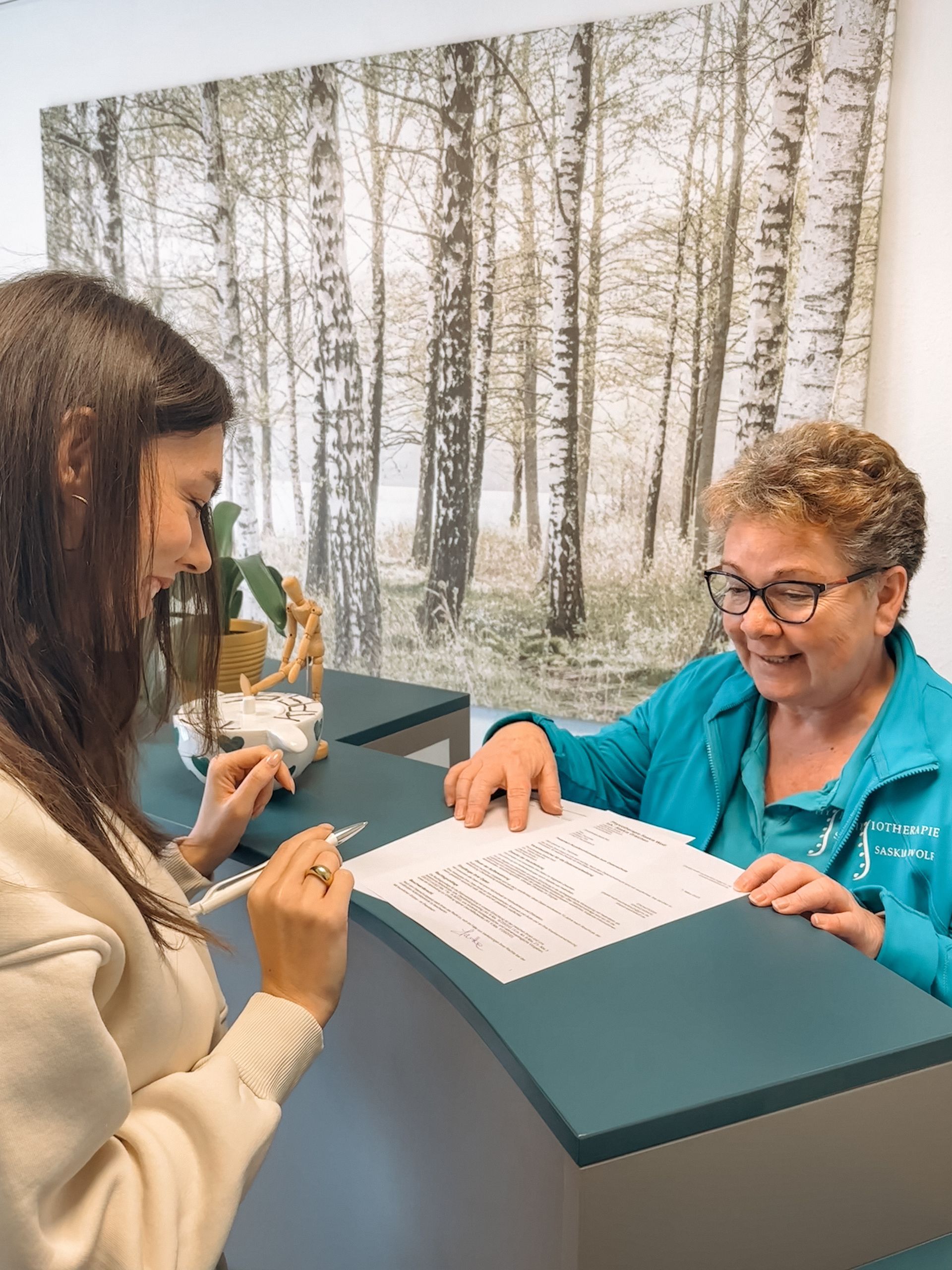 Physiotherapie Saskia Wolf, Physiotherapeutin hält älteren Damen auf Couch mit Gehstock die Hand