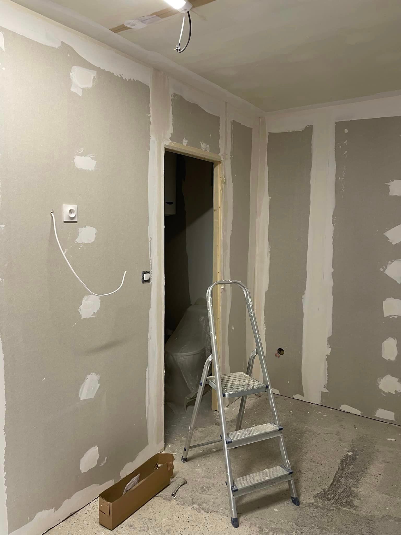 Travaux de plâtrerie sur un mur intérieur