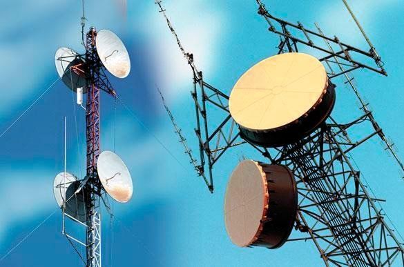 Dos torres de comunicación con antenas parabólicas.