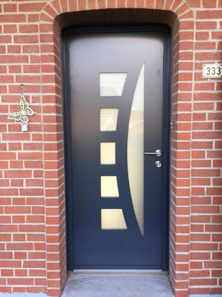 Porte d'entrée bleue avec divers ouvertures et mur de briques rouges