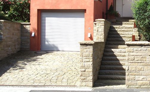 Garage und Steintreppe zu einem Wohnhaus führend/gehörend
