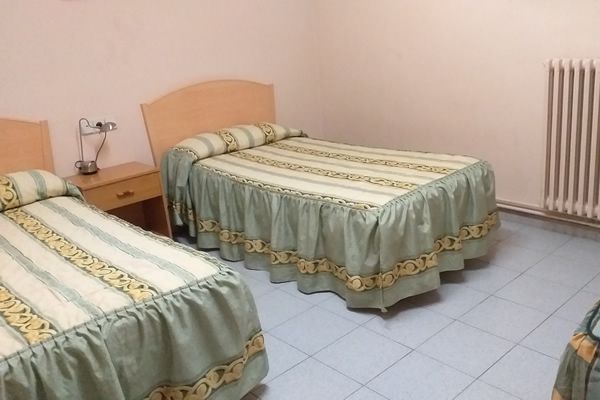 Un panqueque se está cocinando en una estufa junto a una tetera.