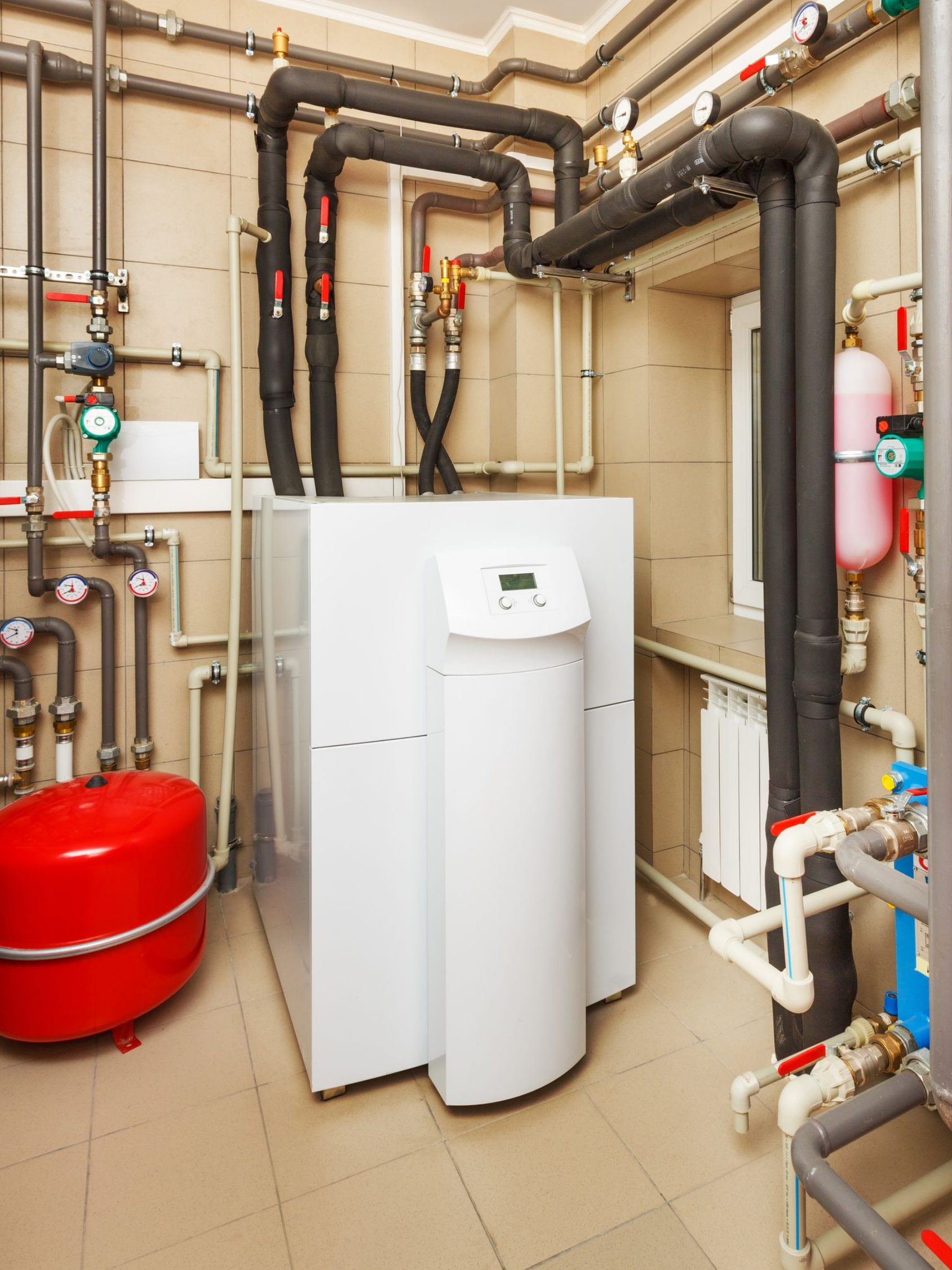 Pompe à chaleur avec un réseau de tuyauterie dans un local technique.