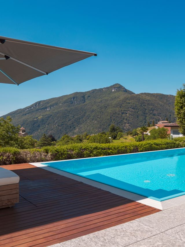 Schéma d'une maison avec des tuyaux souterrains colorés représentant un système de chauffage géothermique.