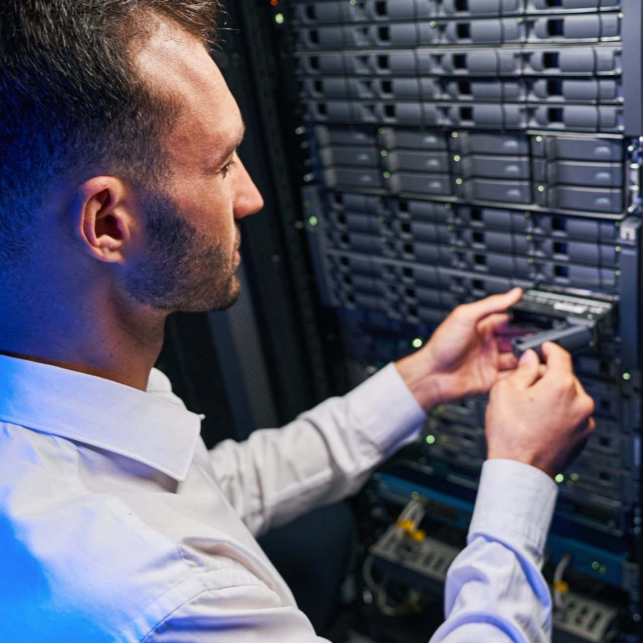 Un homme travaille sur des serveurs dans un centre de données.