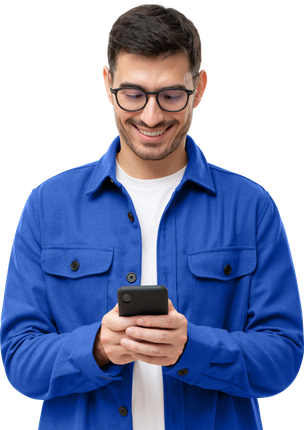Un homme portant des lunettes sourit en regardant son téléphone portable, vêtu d'une chemise bleue.