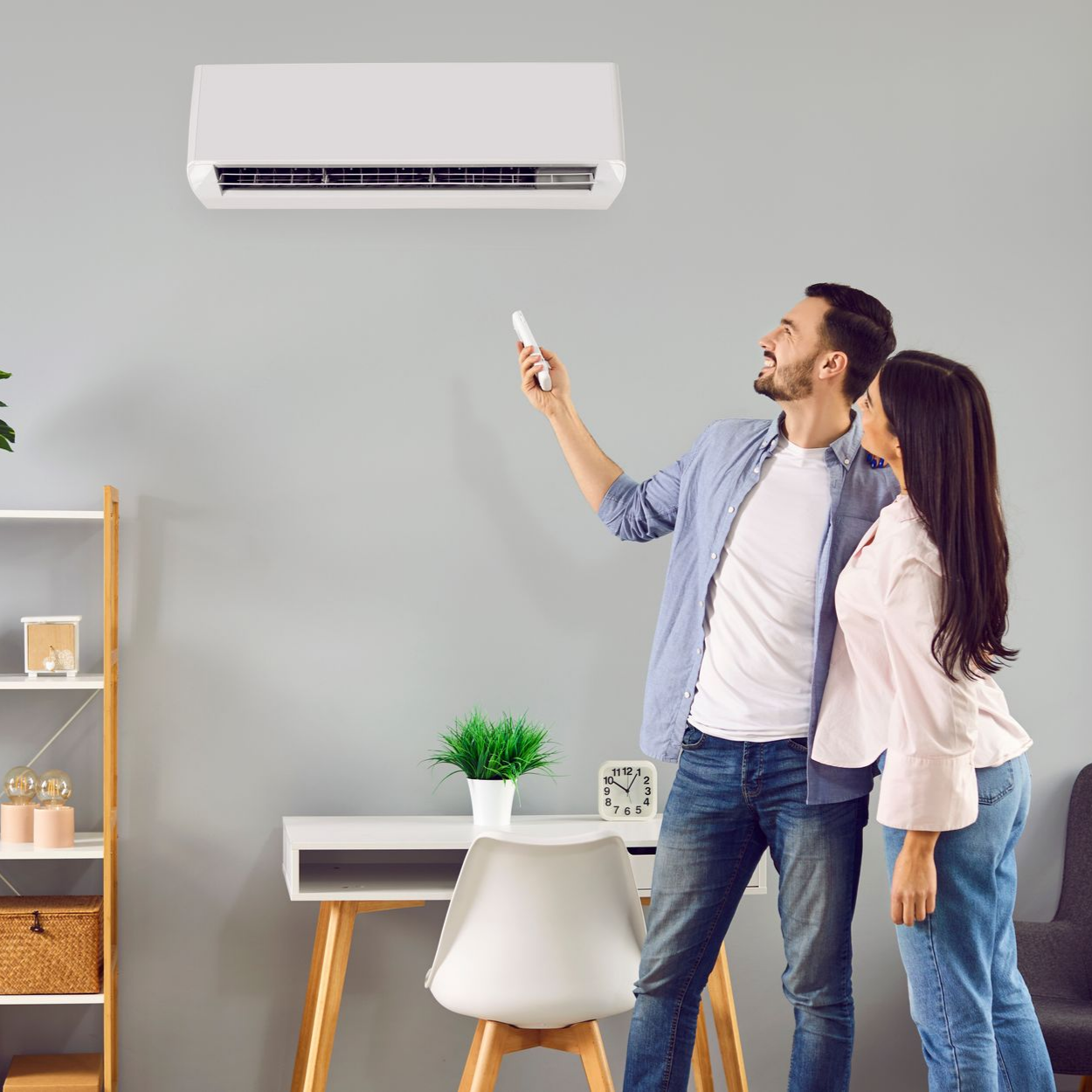 Un couple regarde et active à distance un climatiseur à l'aide d'une télécommande.