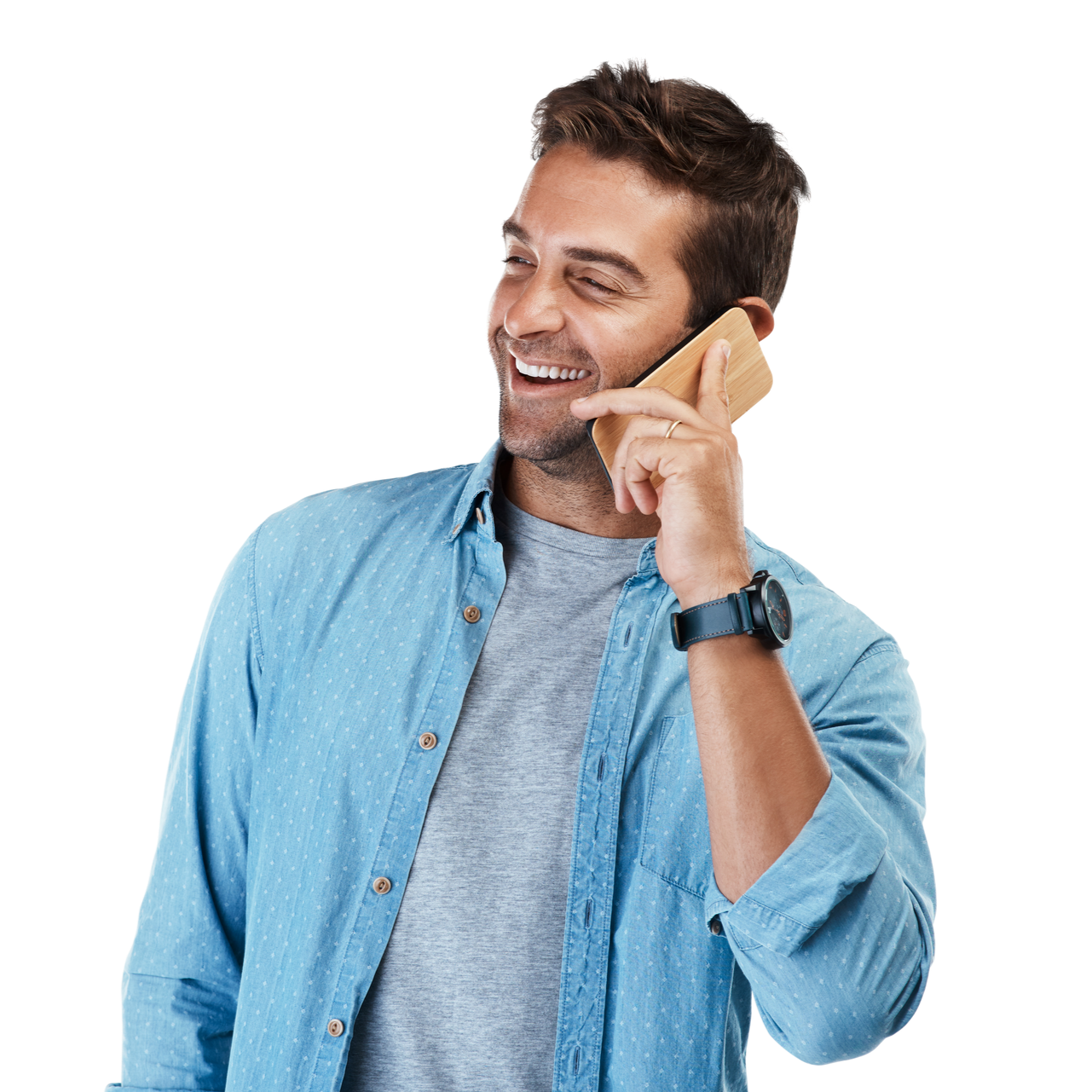 Un homme souriant au téléphone, vêtu d'une chemise bleue.