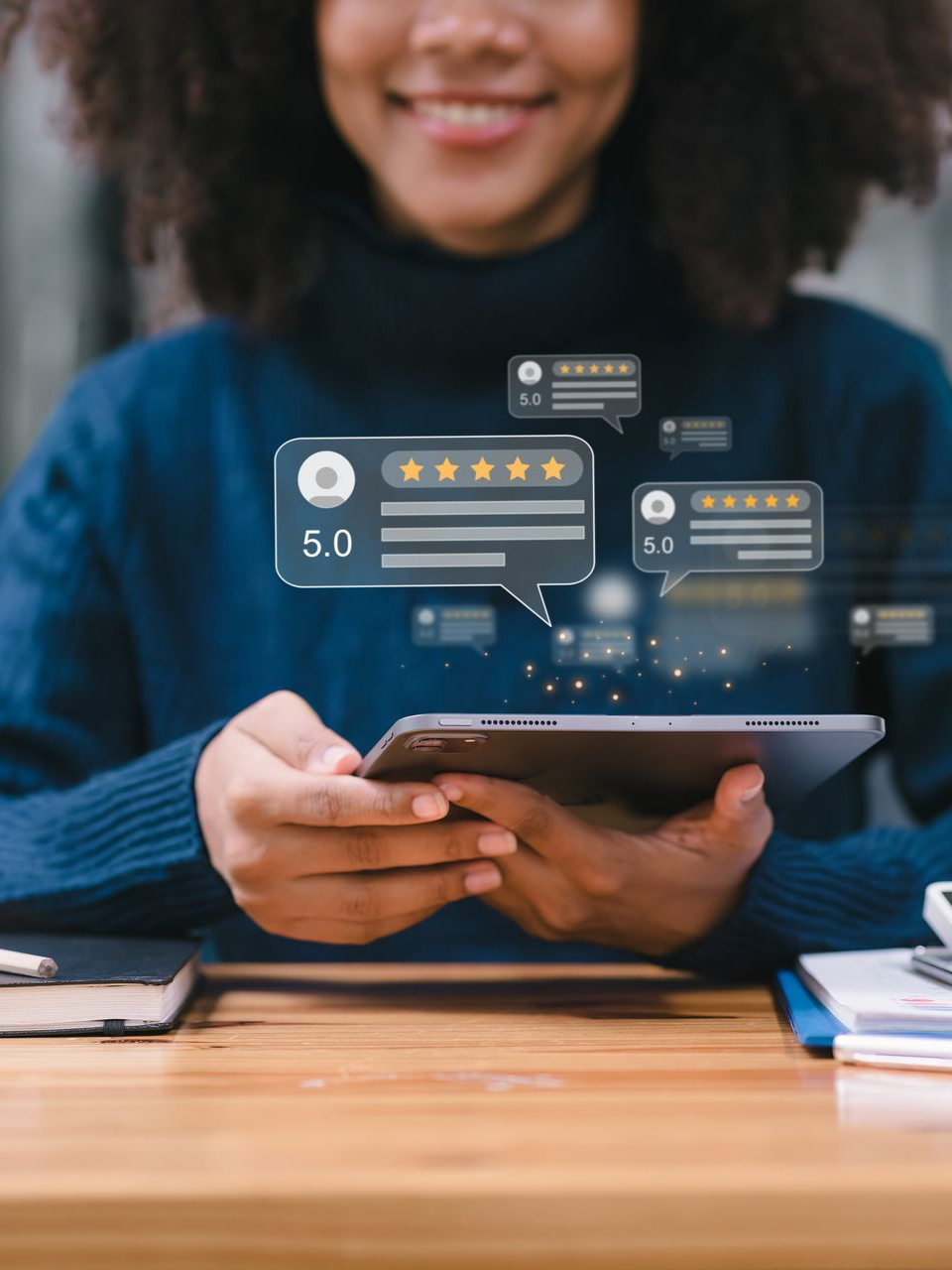 Personne souriante, tenant une tablette affichant des avis en ligne avec des étoiles flottant au-dessus.