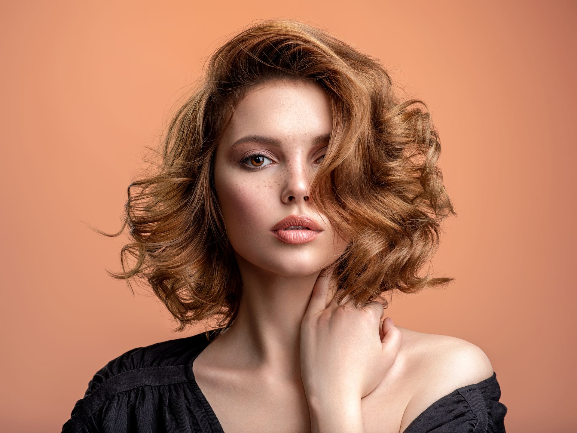Portrait d'une femme aux cheveux ondulés à épaules dénudées