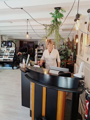 Intérieur lumineux du café avec un comptoir incurvé en bois et un membre du personnel derrière.