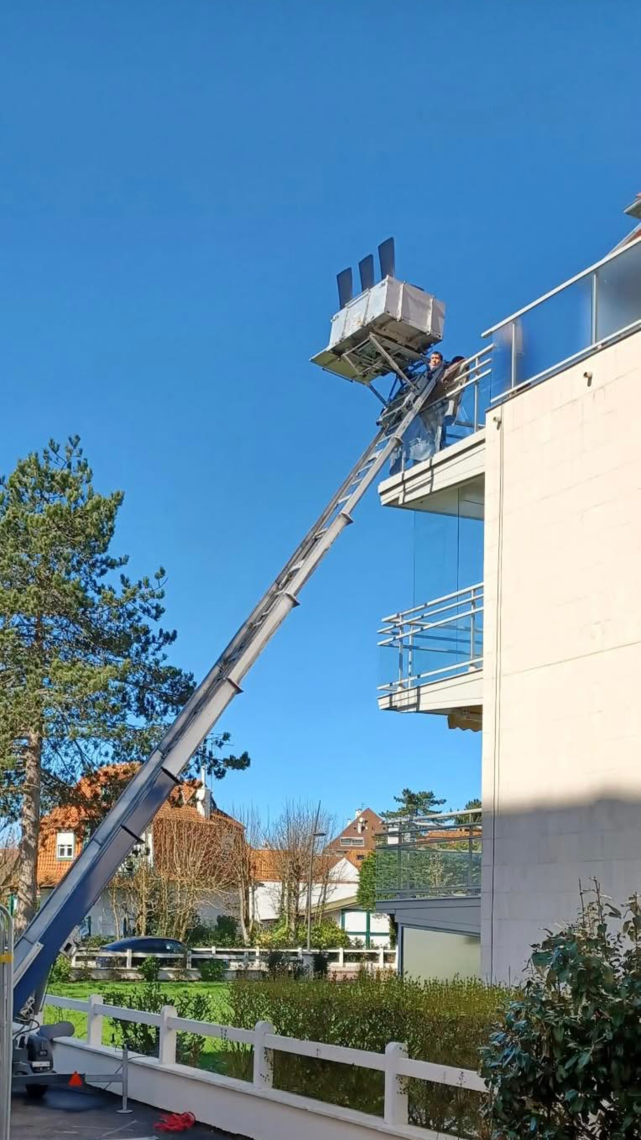 Un homme réceptionne un meuble en haut d'un monte-meuble