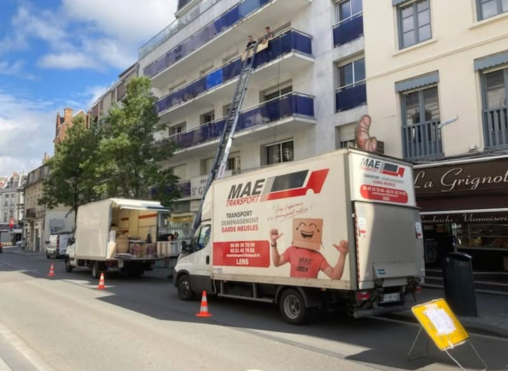 2 hommes réceptionnent les cartons montés par le monte-meuble