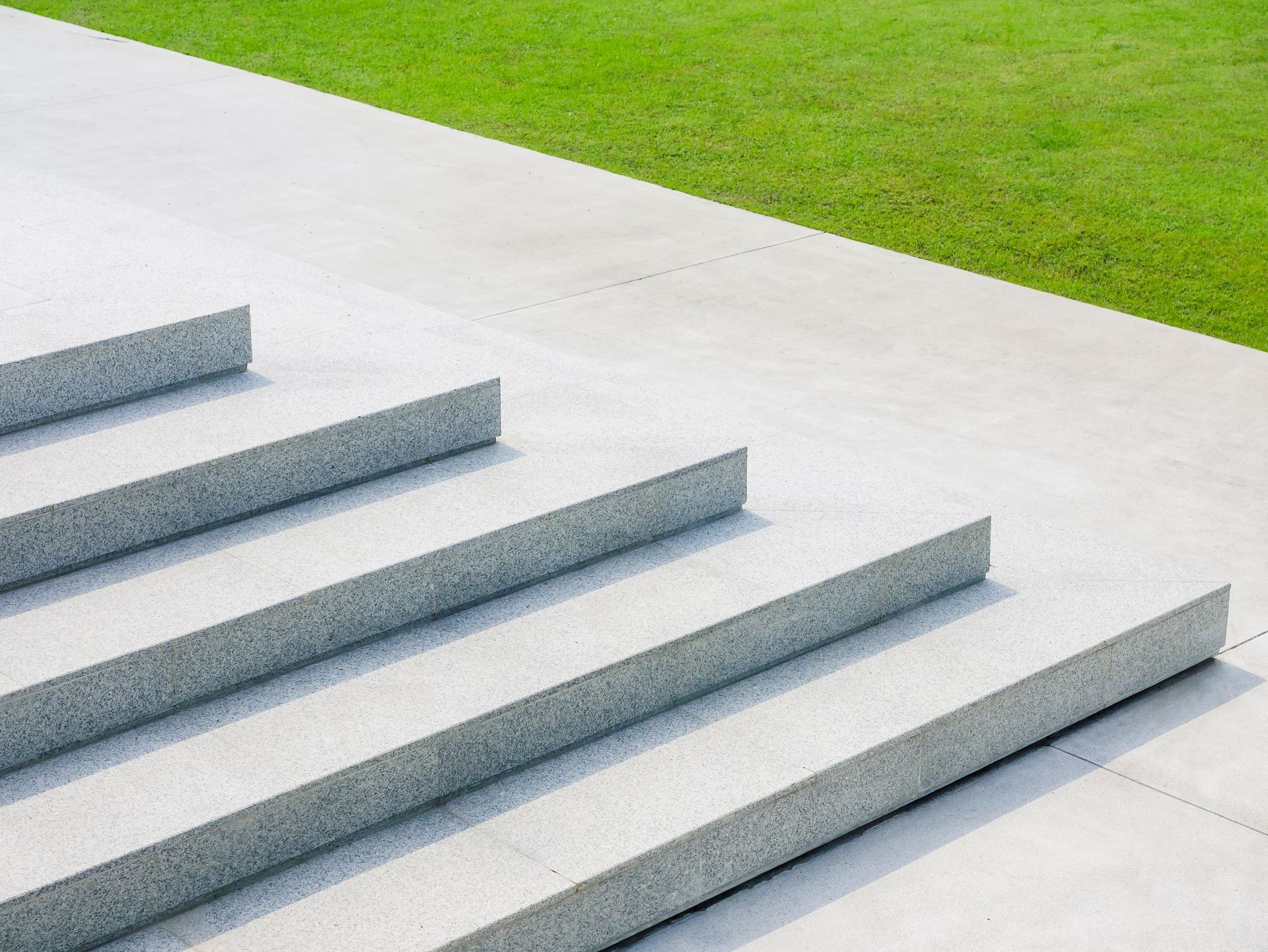 Betontreppe neben einem grünen Rasen.