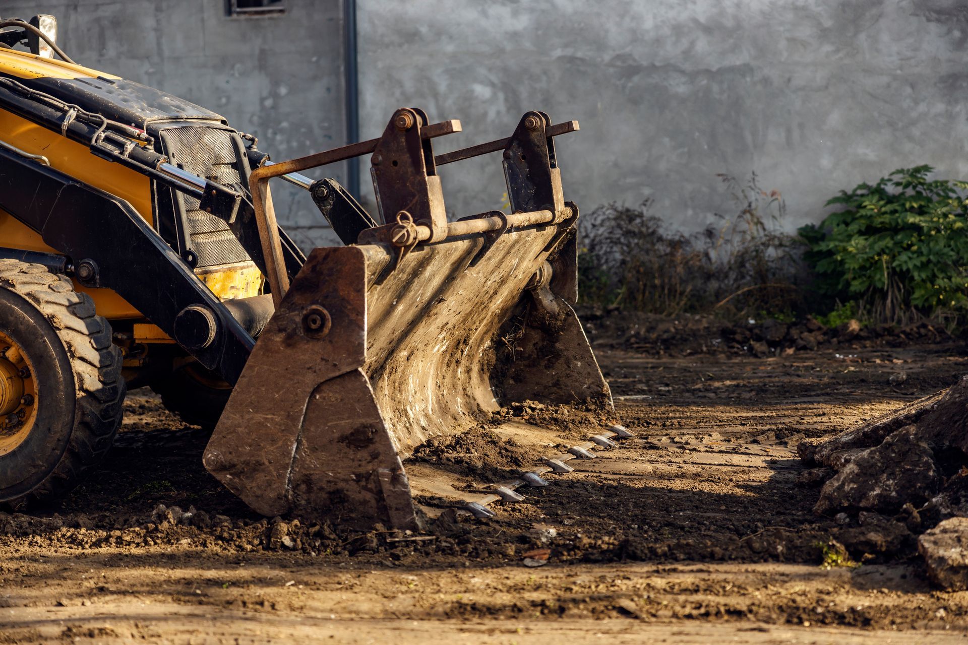 Gelber Bulldozer mit seiner Schaufel beim Aufschaufeln von Erde.