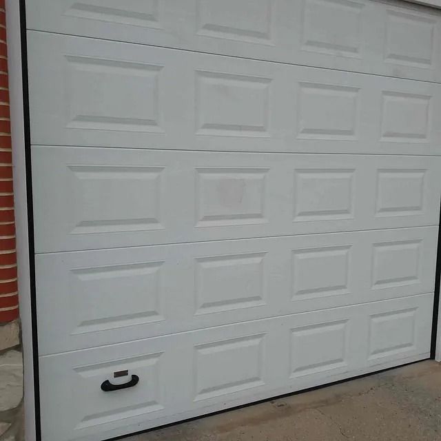 Una puerta de garaje blanca con una manija negra.