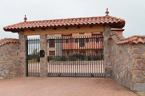 Un muro de piedra con una puerta que conduce a una casa.
