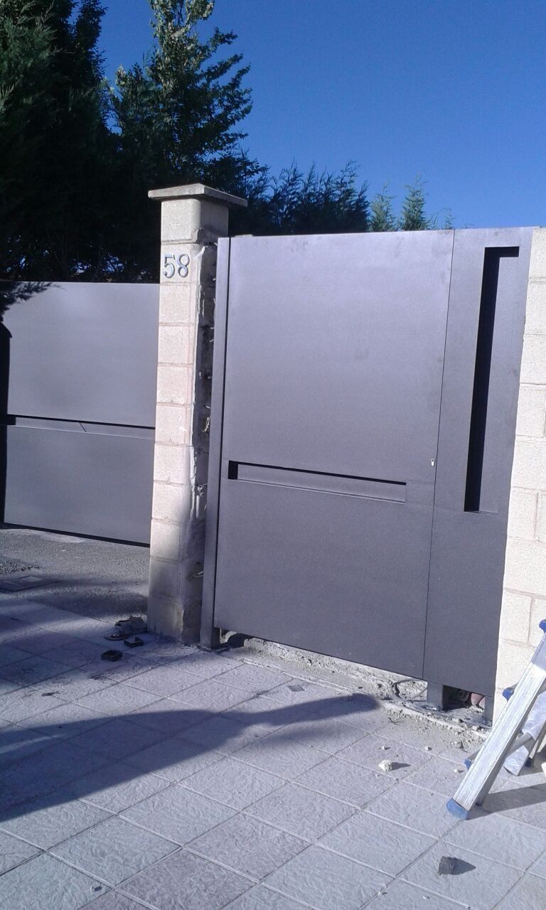 Una puerta de acero inoxidable está junto a una pared de ladrillos.