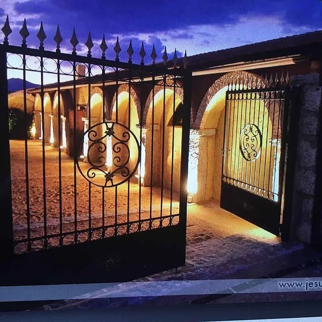 Una puerta de hierro forjado se abre a un edificio.