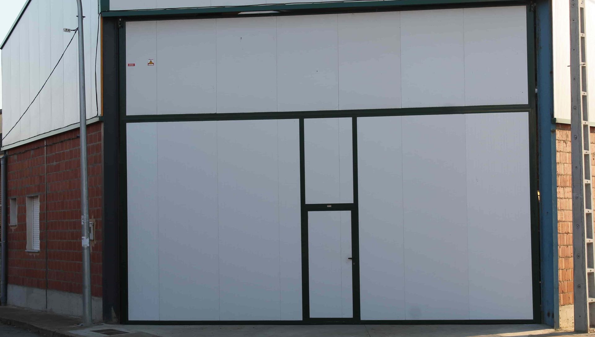Una gran puerta de garaje blanca con marco negro