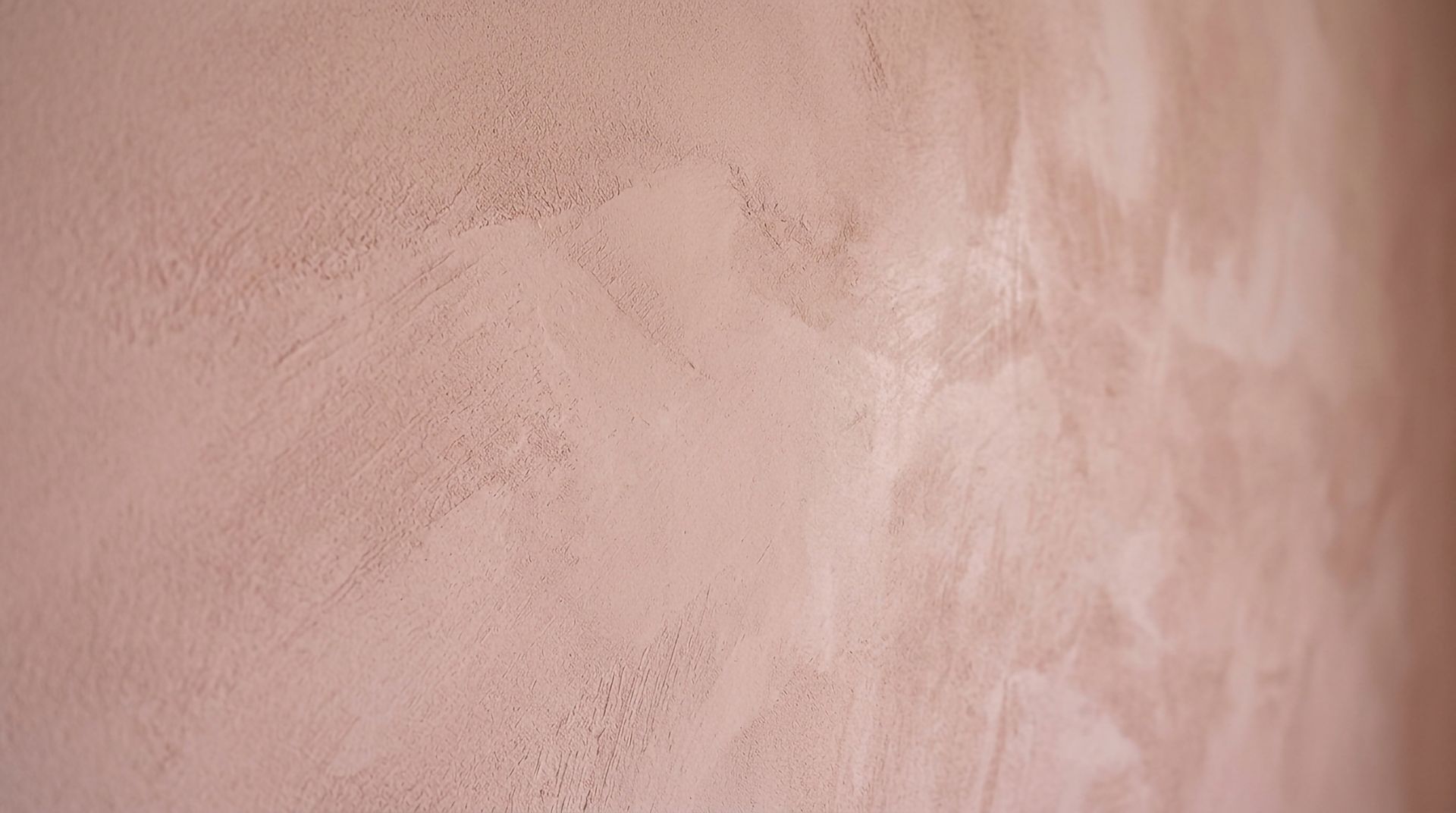 Gros plan sur une surface lisse texturée rose beige avec une fine strie verticale.