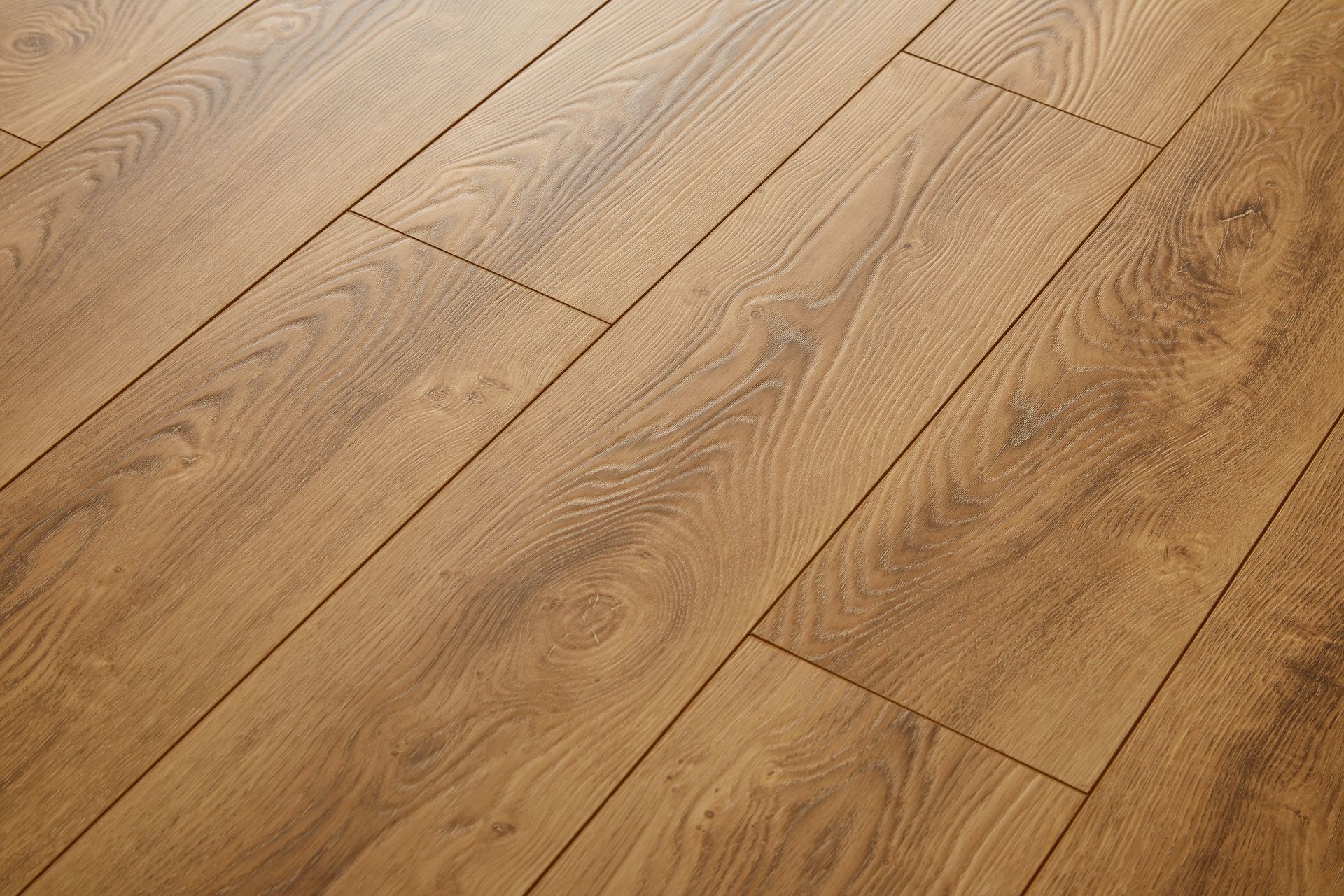 Gros plan sur un parquet en chêne clair avec joints de lames apparents et veinage naturel.