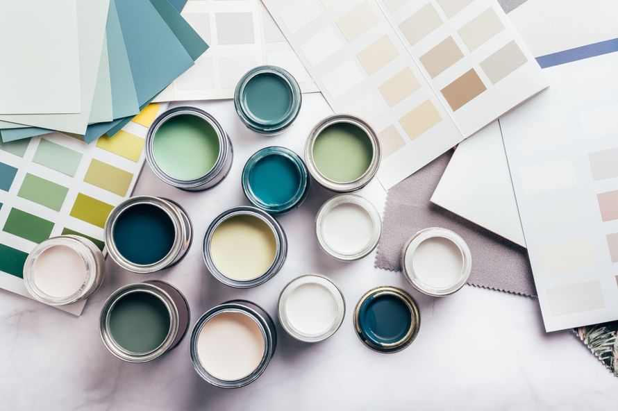 Des échantillons de peinture et des nuanciers disposés sur une surface blanche