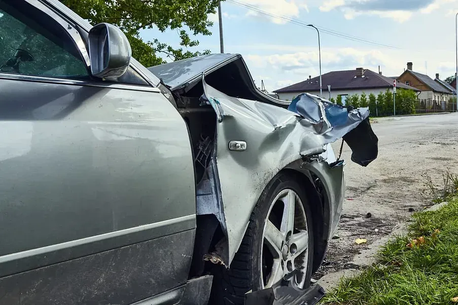 Un coche averiado está aparcado al costado de la carretera.