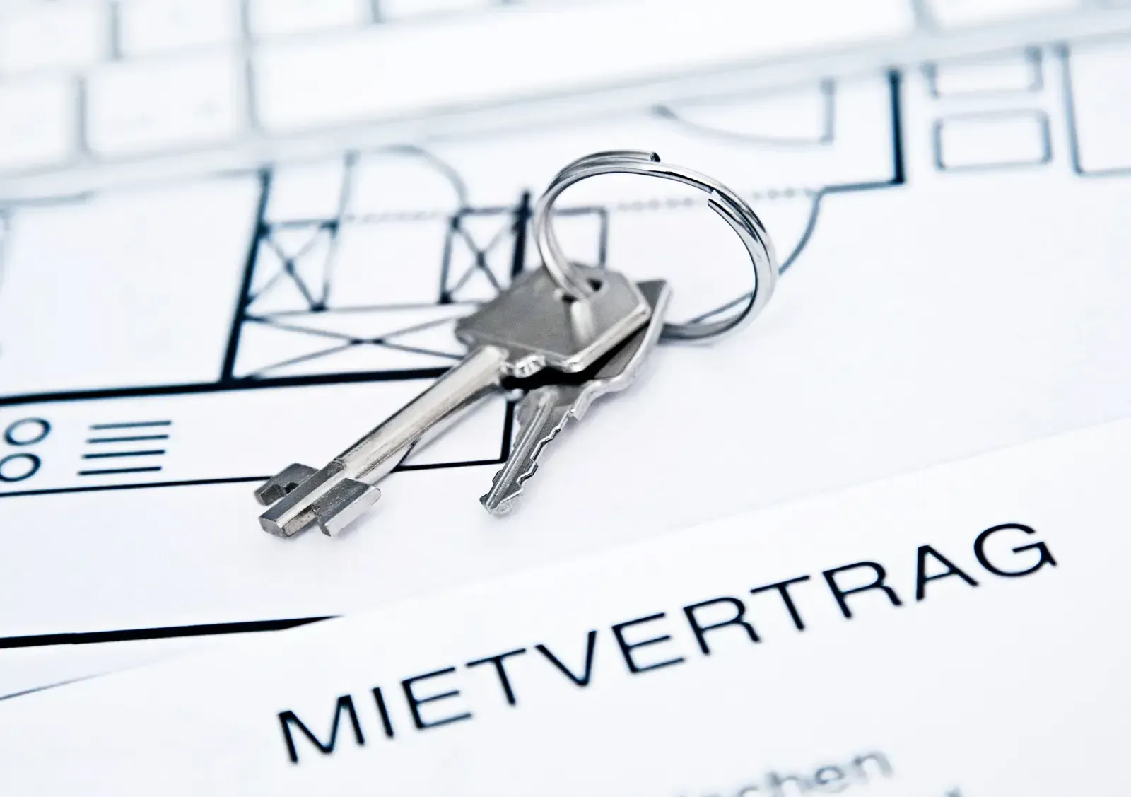 Ein paar Schlüssel auf einem Stück Papier mit der Aufschrift „Mietvertrag“