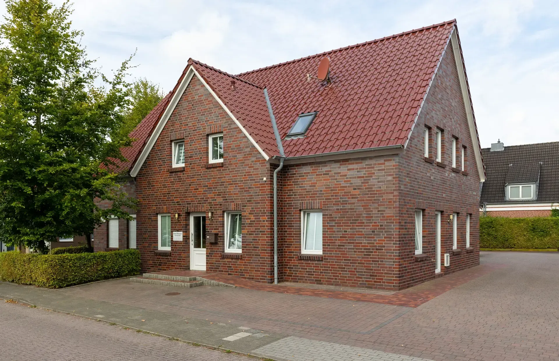 Ein großes Backsteinhaus mit einem roten Ziegeldach