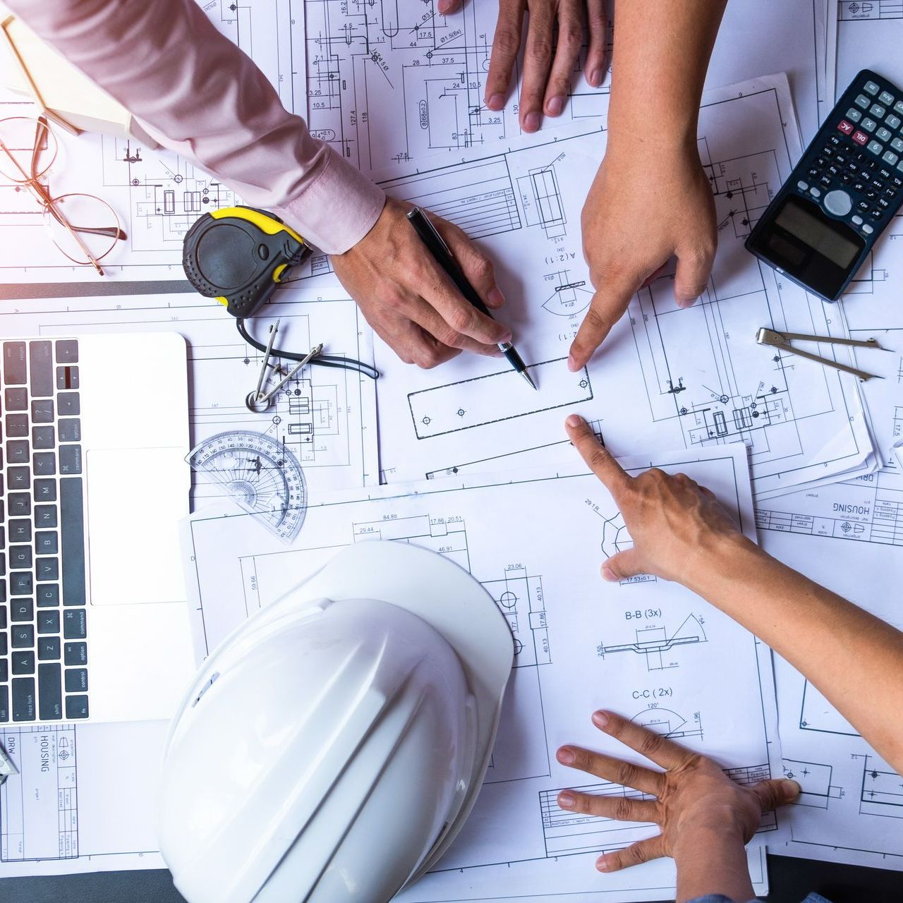 Des professionnels qui échangent autour de plans d'une maison