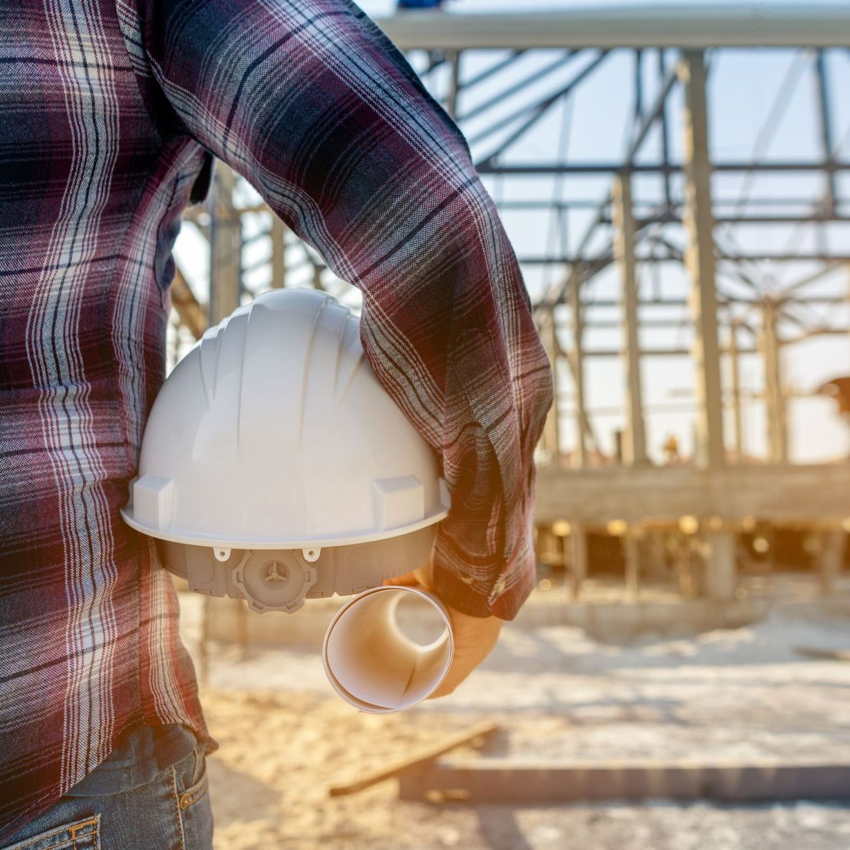Un ouvrier du bâtiment qui tient un casque de chantier